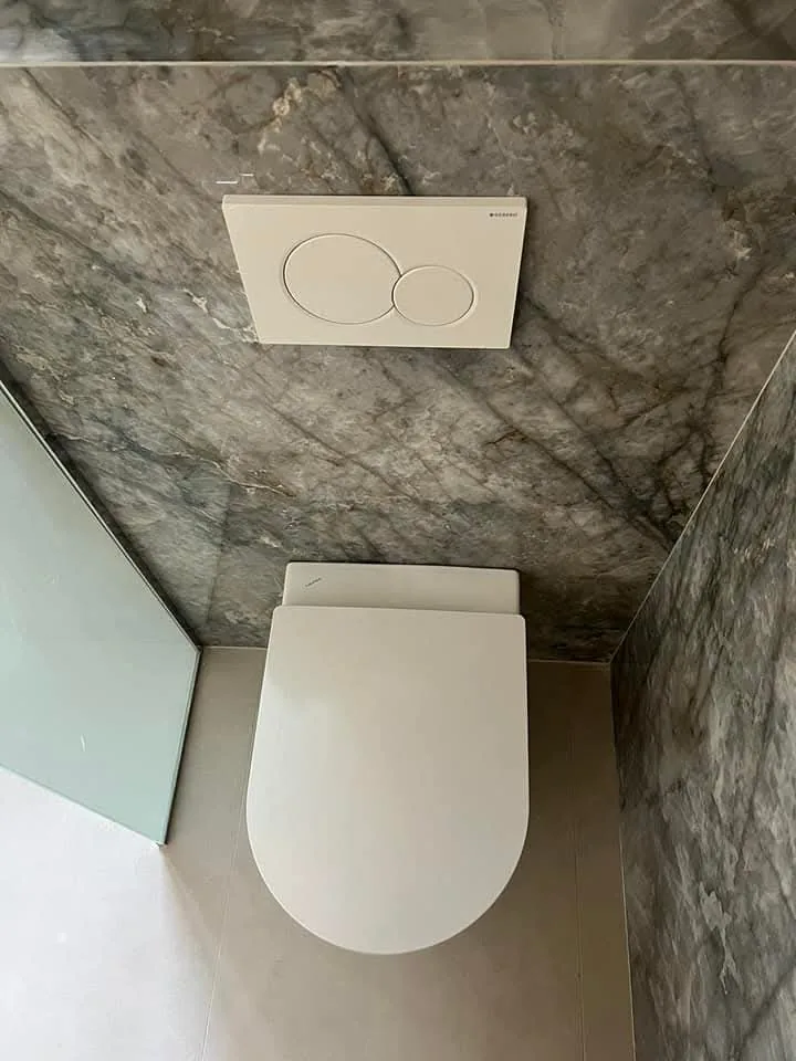 Wall-hung toilet against dark stone-look tile in Cromwell, Connecticut