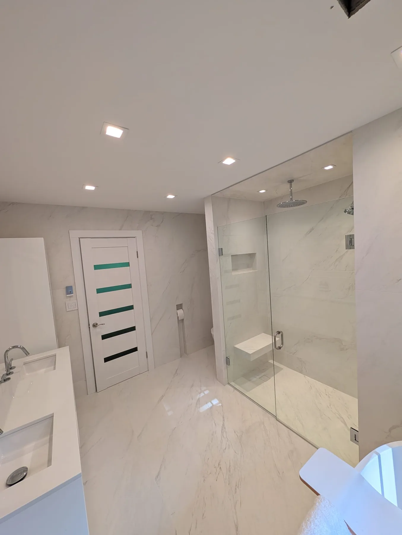 Glass shower and pale tile in the Southington bathroom