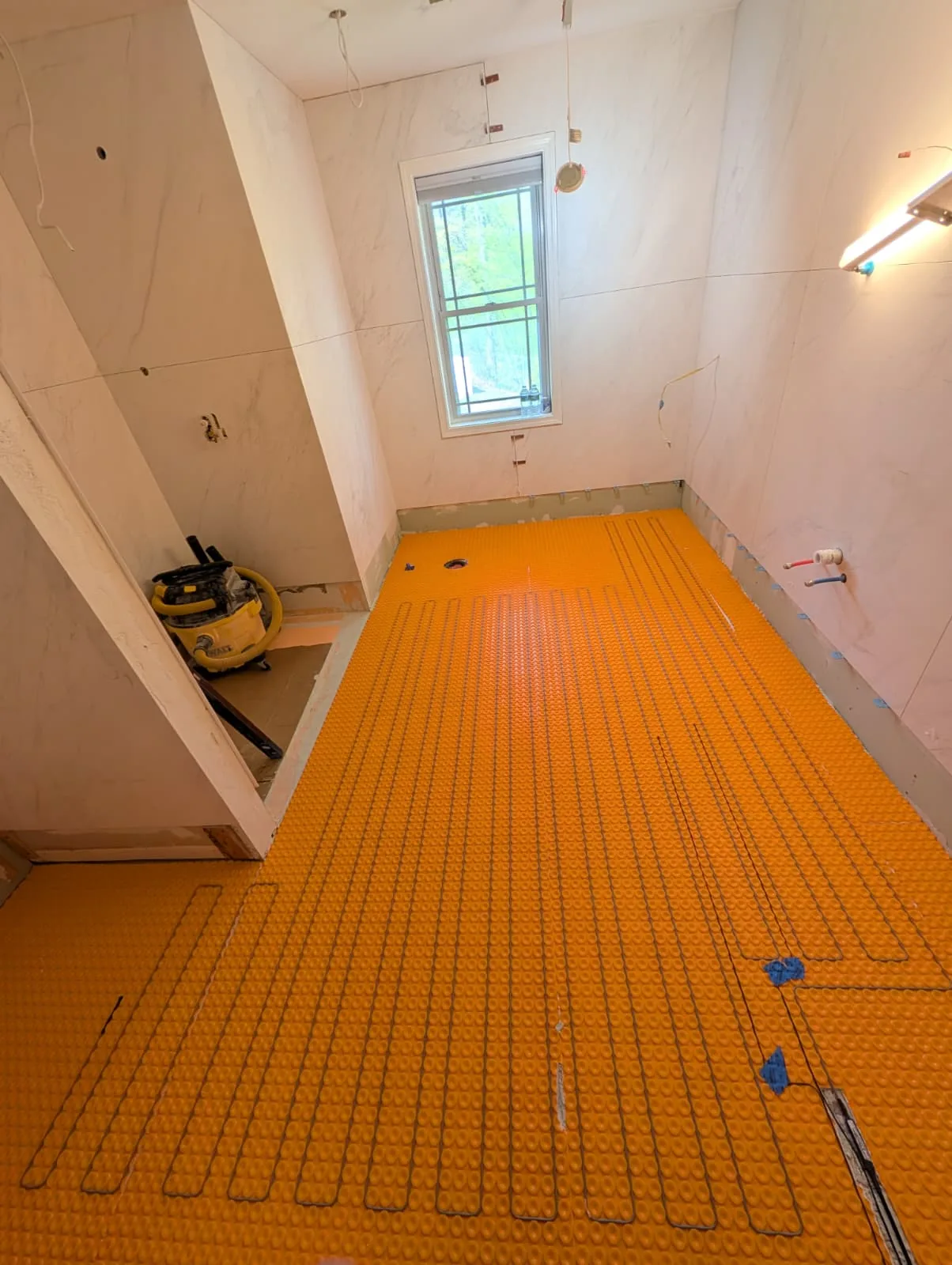 Orange floor-preparation membrane in a Southington bathroom renovation